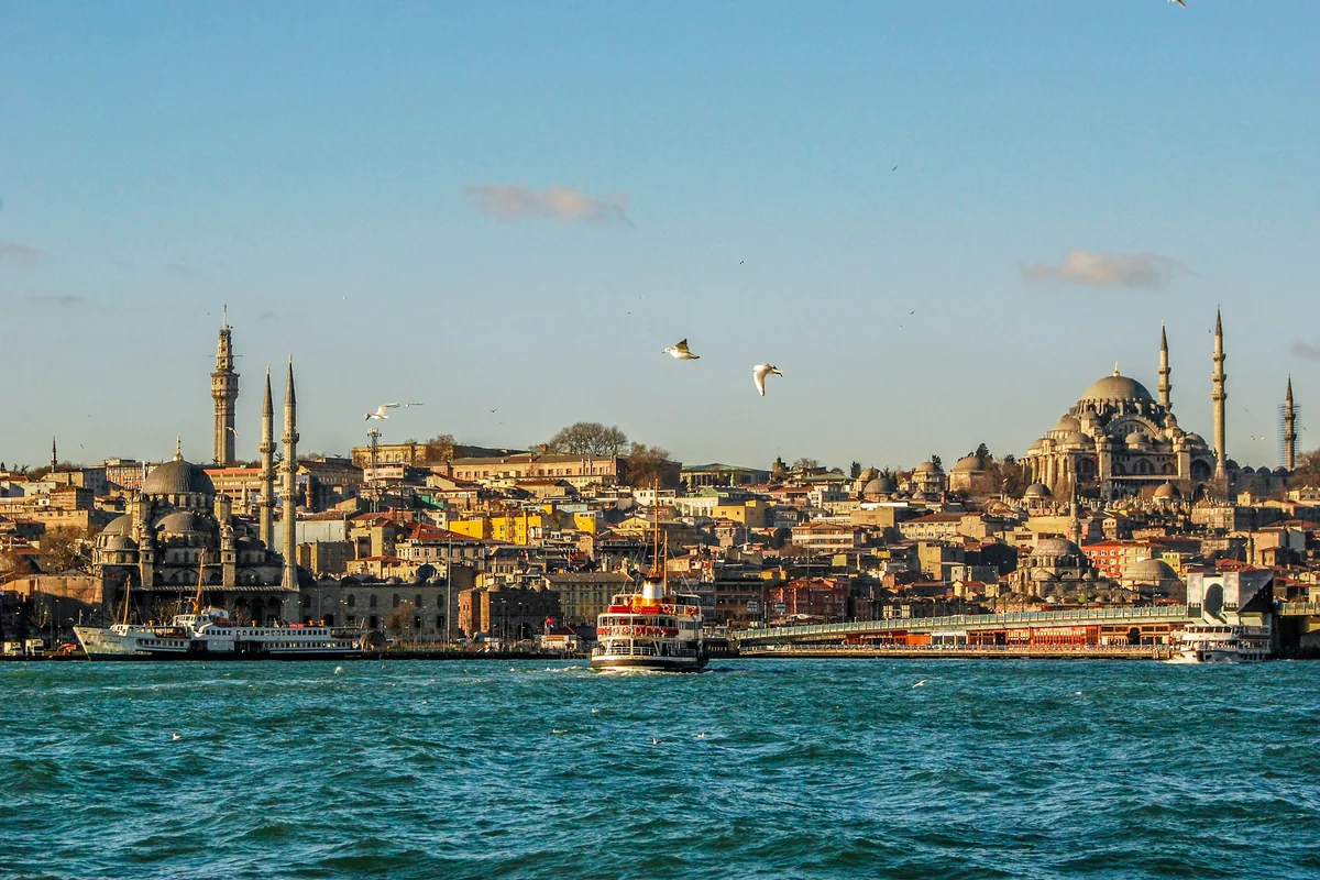 Istanbul waterfront, ferries and historic mosques in warm evening light